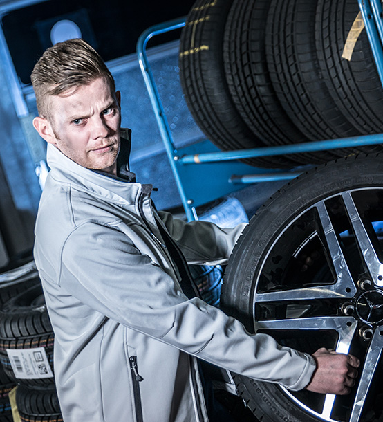 Mechaniker in der Werkstatt mit Reifen